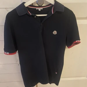 Moncler piké - Säljer en mörkblå moncler pike i fint skick. Storlek M. Har inget äkthetsbevis men ser inget som tyder på att den skulle vara fake. Hör gärna av er vid ytterligare frågor!