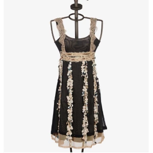 Klänning | Save The Queen - En riktigt snygg och unik lite utsvängd miniklänning från det italienska märket SAVE THE QUEEN. Klänningen är gjord av svart tyll med textila applikationer i färgerna mörkgrön, beige och elfenben som skapar en franseffekt som överlappar den beige tyllen.