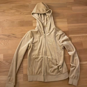 Beige orange juicy couture tröja - Jag säljer denna fina juicy couture tröja för 380 kr. Bara använd en gång och säljer den för den ite används. Den är i dunder bra skick och är i stolek för 10/11 .