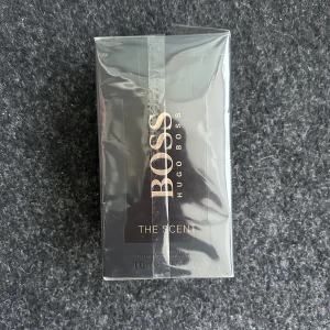 Hugo Boss ”The Scent” 100ml EDT  - Säljer Hugo Boss "The Scent" EdT 100ml i förpackning. Helt oanvänd, enbart oppnad för att ta bild. väldigt populär och eftertraktad parfym. Nypris: 1050kr Mitt pris: 450kr (pruta) Kan även tänka byte mot Dolce Gabbana "The One" EdP. Kom dm vid fler fragor