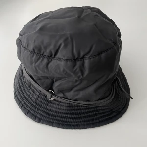Regnsäker och vadderad buckethat - Så fet bucket-hat. Funkar även in på höst och vinter för att hålla knoppen varm. Knappt använd.