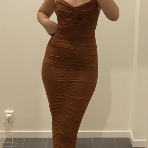 Snygg festklänning  - Helt ny. Endast testad. Lite som en kroppstrumpa, formar kroppen. Lite mer ljusbrun STRL 36