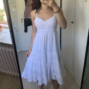 Vit klänning - En söt vit klänning med knappar och virkade detaljer. Passar bra till sommaren och studenten. Storlek 38, stretchig rygg och passar xs-m (bärs av mig med xs). 💓