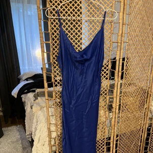Satinklänning  - Nyskick, blå satinklänning. Storleken är L/40 men känns mer som 36-38/M. Väldigt smickrande passform & vadlång