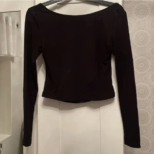 Svart långärmad med öppen rygg - En svart långärmad tröja med öppen rygg från Nakd, inköpt för några månader sedan. Endast testad men tyckte inte den passade bra på mig.