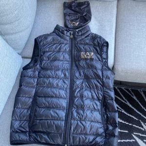 EA7 Väst - Tjena!Säljer min armani väst som är använd max 3 gånger så skicket är som ny man får även med en liten påse där man kan lägga ner den.det är en väldigt tun och skön väst,storleken är Medium jag köpte den på Zalando och nypriset ligger på runt 1300kr