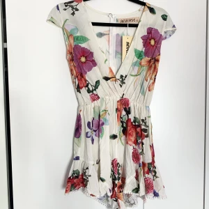 Jumpsuit - En fantastiskt fin, blommig,  jumpsuit med volangkant vid benen som tyvärr är för liten för mig. Aldrig använd! 