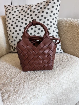 Oanvänd väska från Cala Jade - Säljer en oanvänd väska från norska märket Cala Jade. Jättefin till en sommarklänning eller ljusblåa jeans och t-shirt.  Modell: Misu Mini Färg: Nutmeg  Storlek: 17x16x11 cm  Inköpt i höstas, kvitto finns, för 3900 kr. Dustbag följer med.