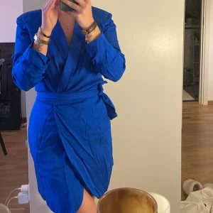 Klänning - Säljer denna superfina kavajklänningen med axelvaddar! Köpt förra sommaren från Zara men kom tyvärr aldrig till användning. Den går omlott vilket ger en snygg passform och framhäver former! Oanvänd!! 