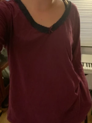 Tröja  - Rosa och blå tröja med spets och en liten rosett. Aldrig använd, men köpt på second hand. 