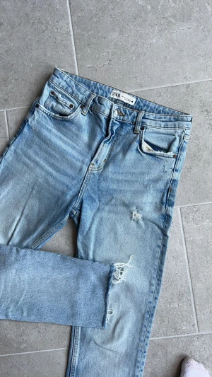 Ljusa jeans  - Ljusa jeans från Zara i mycket bra skick. Lite slitningar som ingår i designen. Fransade längst ned. Lite stora i storleken 