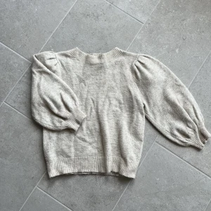 Stickad T-shirt  - Beige stickad T-shirt med balongärmar som slutar vid armvecket. Mycket bra skick ! 