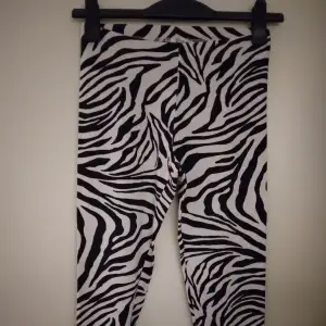 Svartvita zebramönstrade leggings med dragkedjor längst ner på benen, begagnade men inte trasiga. Strlk 34-36/SMALL. 