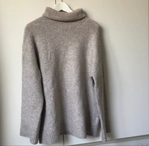 Beige polotröja - Superfin beige stickad tröja. Breda muddar och justerbar polokrage