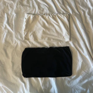 Svart och vit bandeau-topp - En svart och en vit bandeau-topp. Den vita är lite nopprig på sidorna men det märks inte när den sitter på. Går att ha under en blazer exempelvis. 15 kr st och 25 kr för båda. 
