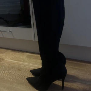 Svarta höga pumps (stretch)  - Stl 38  Svarta höga klackar i mjukt material därav lite stretchiga 
