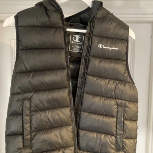 Champion dunväst 150/155 - Fin svart dunväst från Champion. Nyskick. Storlek 150/155