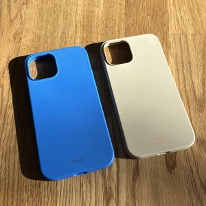 Mobilskal - 2 helt oanvända IPhone 12 skal från Holdit. Blå och ljusbeige. Nypris är 200kr/st men säljer för 90kr/st. 