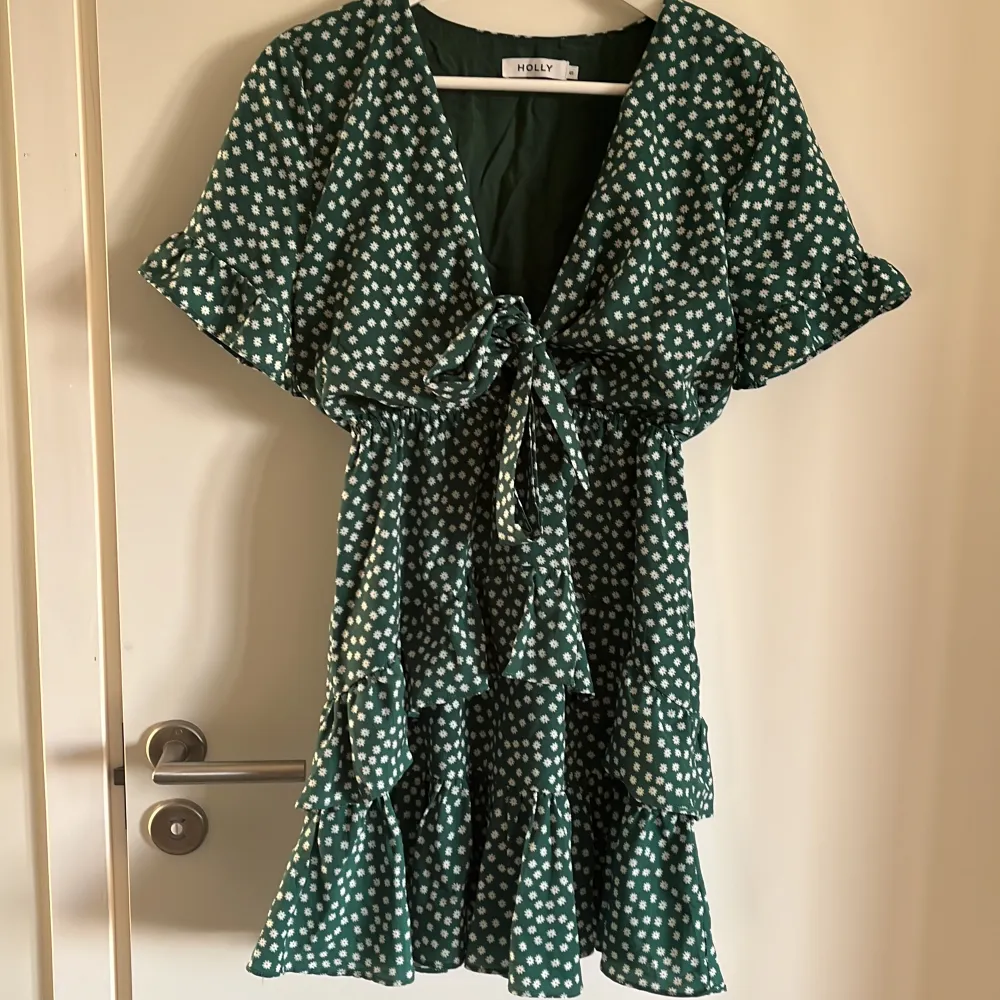 Grön klänning i vippig modell. Oanvänd. Nypris 749 kr. Strl S. Från axel till fåll 75 cm.. Klänningar.