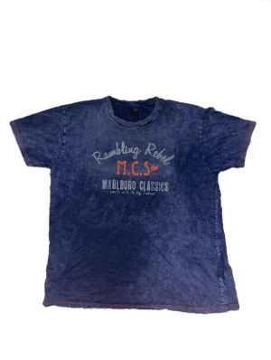  Vintage graphic t-shirt - Tröjan vintage i en blå färg. Den har ett coolt tyck och med röda sömmar. Den är baggy (M-L)