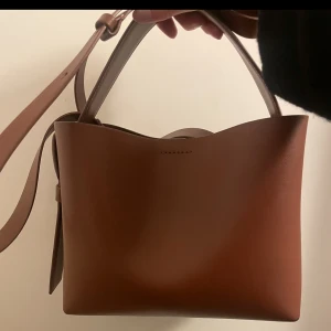 BRUN ARKET VÄSKA - Säljer min bruna väska från Arket som just nu är slutsåld på hemsidan! Den är använd men har inga defekter. Köpt för 2000kr