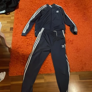 Adidas Sst - Säljer den kända Adidas sst tracksuiten i storlek 170-176. Man kan köpa överdelen och underdelen separat men båda fungerar bättre. 300kr för hela set