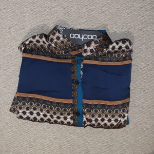 Skjortklänning - Klänning med snören insydda vid midjan för att kunna justera/fixa passform. Orientaliskt mönster med fina färger. Skönt material! Helt ny! 