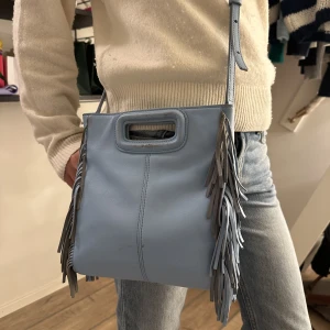 Maje väska - Ljusblå äkta Maje väska i stora modellen! Välanvänd med slitage på vissa ställen, syns på bilderna men kan skicka fler om det önskas. Nypris ca 3000kr men mitt pris 850kr. Kan mötas i Stockholm annars står köparen för frakten!💙💙💙💙kan byta mot ngt annat!