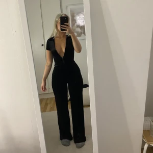 Jumpsuit - Jumpsuit i velour material. Formar kroppen sjukt fint och har en dragkedja  där man kan justera urringningen. Storlek xs.