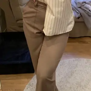 Högmidjade brun/beiga kostymbyxor med raka ben från Weekday. Storlek 42.  Kan mötas upp inom stockholm eller skickas mot frakt!✨