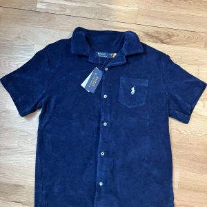 Polo Ralph Lauren - Polo Ralph Lauren terry piké. short sleeve terry camp shirt. För liten på mig så säljer den. HELT NY!!!. Köpt för 1300kr