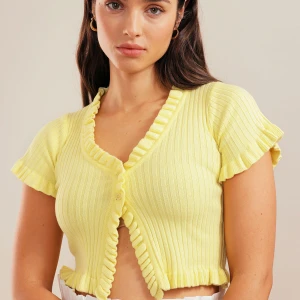 Croppad cardigan  - Cardigan från Chiquelle med volanger. Använd en gång. Inga defekter. Färgen är ljusblå. Jätteluftig och skön. Kommer tyvärr inte till användning. 