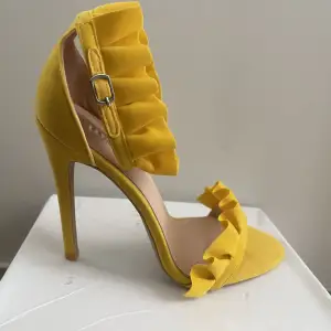 Säljer ett par frill detailed heels in yellow faux suede. Oanvända 