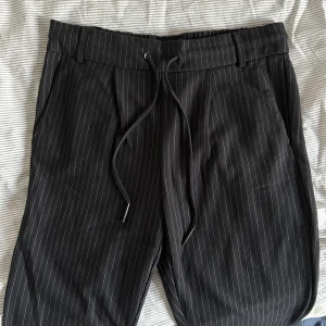Kostymbyxor  - Svarta kostymbyxor med vita ränder från Only. Stretchigt material. 