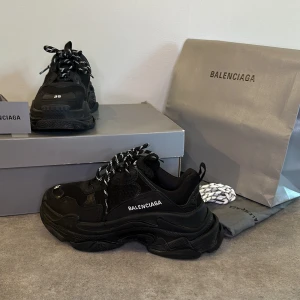 Balenciaga Triple S Black 38  - Nu säljer jag mina älskade Triple s, som inköptes 2019 i New York på Balenciaga. Dom är måttligt använda. Strl 38 men passar 39. Endast meet up i Stockholm. Pris förhandlingsbart vid snabb affär. 100% äkta och kommer med dustbag, extra skosnören mm.