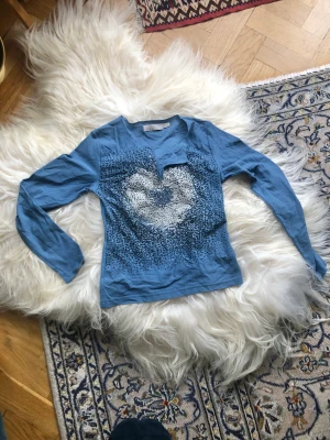 Topp/tröja från Ichi - Topp/Tröja från Ichi med ett glittrigt hjärta framtill! Tröjan är i jätteskönt, tunt tyg som sitter tajt och smickrande på kroppen :) 
