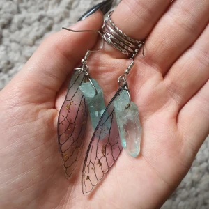 Fjärilsvingar & kristall örhängen - Söta örhängen med fina guld falkes! Gjorde i troligen acryl. Knappt använda så därav säljer jag dem. Tyvärr så följer inga pluppar med. Frakten är inräknat i priset!!✨️