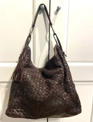 Handväska  - Handväska i skinn ca 30 cm hög + han/axel rem blommigt foder med 1 innerficka med dragkedja och 2 mindre