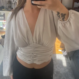 Satintopp  - Strl 34. Använd en gång, som ny. Ballongärmar!