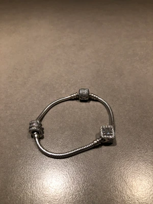Pandora Silverarmband + två berlocker  - Säljer nu mitt Pandora armband som jag köpte till min exflickvän, äkta sterlingsilver (s925ALE)