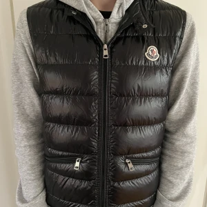 Moncler Gui Väst - Äkta väst! Säljer pågrund då den ha blivit liten och jag inte använder den. Skickas i lådan, kom dm om kvitto. (Original Pris 6,500kr)