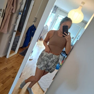 Sommarshorts - Sommarshorts i skönt stretchigt material. Nedtonad vit färg med svart/bruna mönster. (Ignorera hur skrynklig den är, hittar inte mitt strykjärn😅) 
