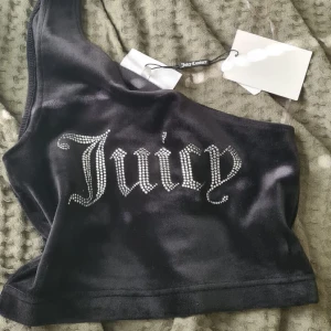 Juicy topp - Skit snygg svart juciy topp med ett axelband. Den är i nysick och aldrig använd utan bara testad, orginalpris 400 kr, köpt på Urban Outfitters. Skriv om du är intresserad 😊