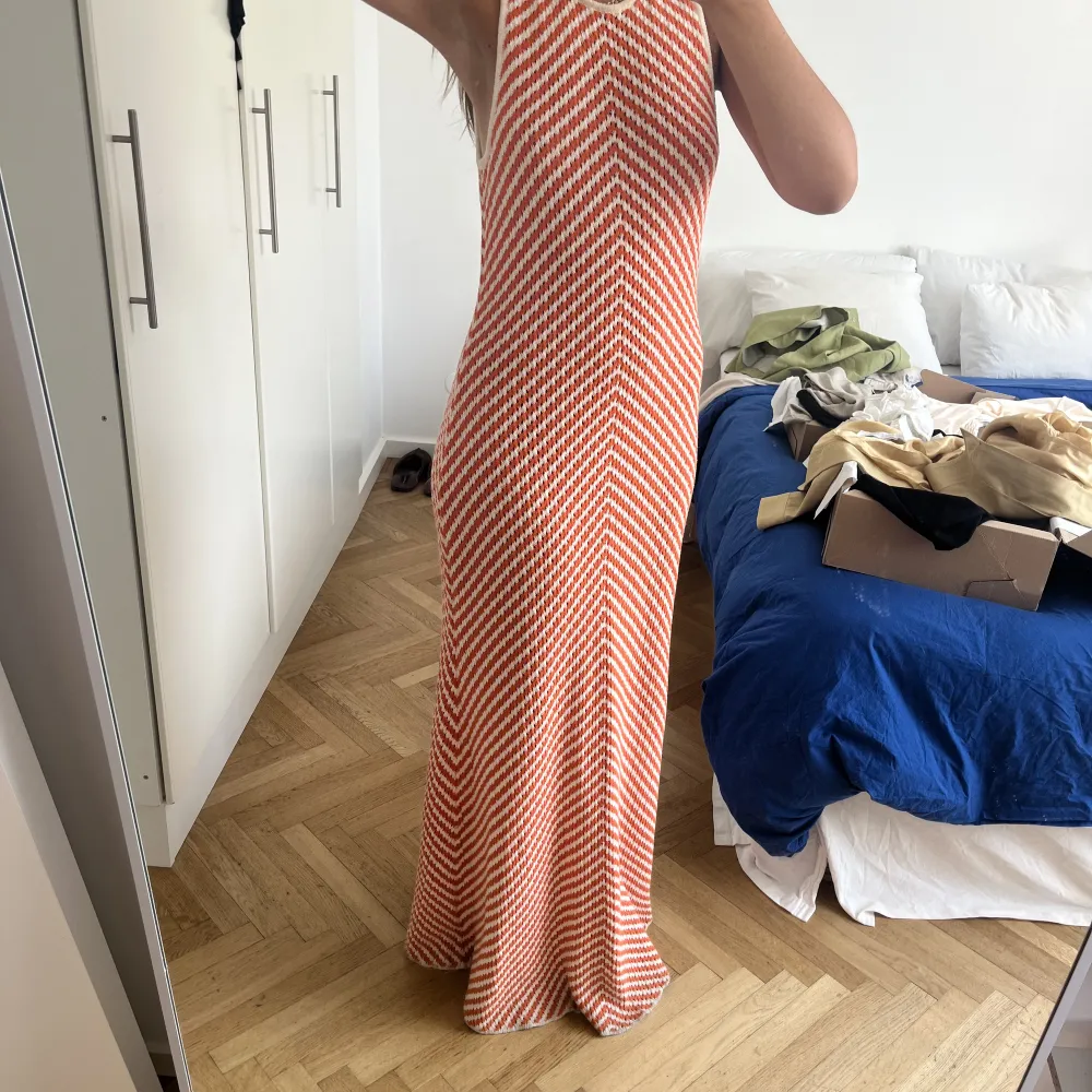 En stickad maxi klänning från Zara!  I ett orange vitt mönster!  Stl XL men jag är en M i vanliga fall så passar även mindre storlekar!  Hellång (jag är 178cm)   Endast använd vid 1 tillfälle så den är i nyskick. Klänningar.