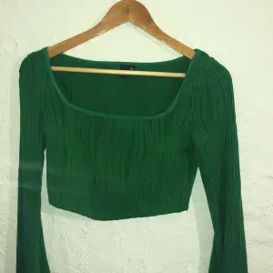 Fin grön tröja med fin textur. Använd ett fåtal gånger. Utsvängda armar och sitter precis över naveln.