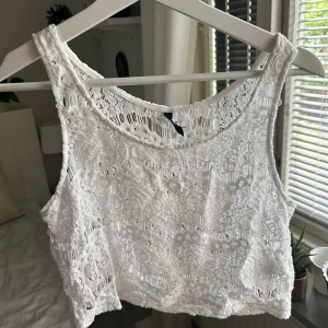 Virkad topp  - Vit virkad topp från H&M som passar perfekt att ha över bikinitopp. Storlek 36 men passar XS-M. 
