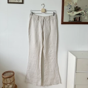 Linnebyxor  - Beigea LÅNGA linnebyxor i 100% linne. Tyvärr för liten i storleken för mig därav ingen blid med byxorna på.  Mått: Midja - 40 cm Total längd - 108 cm Innerbenslängd - 86 cm Lår - 25 cm  Ben bredd längst ner - 28 cm 