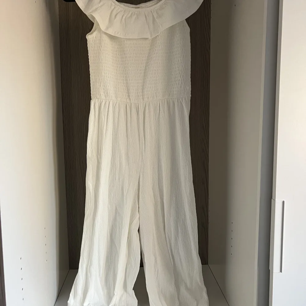 Vit jätte söt jumpsuit. Går att ja på axlarna men också off shoulder . Klänningar.