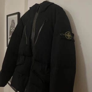 Stone Island Jacka - Stone island water repellent wool down filled Jacket.  Riktigt fin vinterjacka i grymt skick. Jackan är fodrad och helt vattentät vilket är perfekt för en svensk vinter.  Finns inbygg balaclava och handskar som lätt går att ta av med dragkedja.  Storlek S