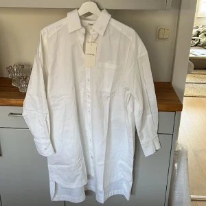 Vit långskjorta/klänning - oanvänd - Vit långskjorta el klänning. Oanvänd!